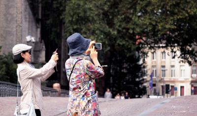 Two Chinese tourists taking photos in Spain.