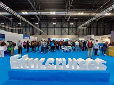 Vista de la sección FITUR Cruises en FITUR, con numerosos profesionales en torno a un gran  cartel de este espacio.