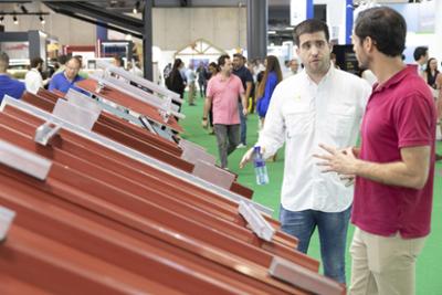 Profesionales en un stand de GENERA que presenta soluciones para tejados