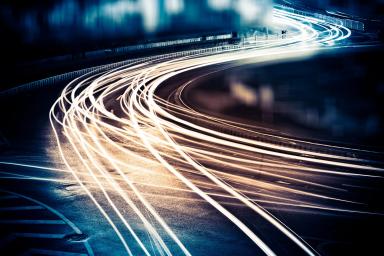 Image of road with moving illuminated cars