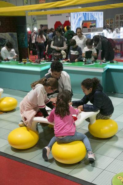 aspecto parcial niños jugando con juegos de mesa en estand juvenalia 2021