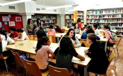 estudiantes conversando en la biblioteca