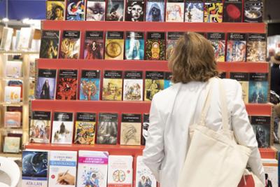 A woman with her back to a display case filled with books