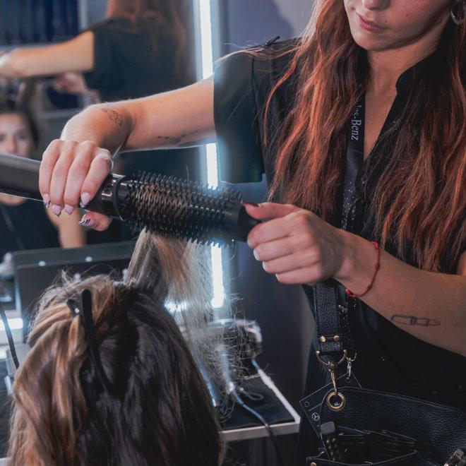 Hairdresser styling a model's hair at Mercedes-Benz Fashion Week Madrid