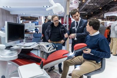 Professionals at a booth checking the operation of a new dental chair for dental patients