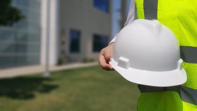 Operario sosteniendo un casco de seguridad