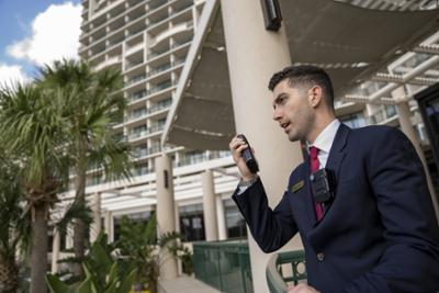 Un profesional de seguridad en la puerta de un edificio utilizando el nuevo ecosistema de seguridad de Motorola Solutions.