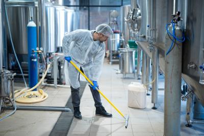 A worker performing cleaning tasks in an industrial facility