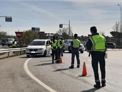 Several Civil Traffic Guards and various vehicles at a road safety control.