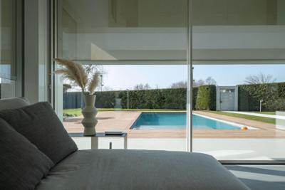 Una habitación con puertas de cristal y vistas a una piscina que tiene integradas soluciones Nice