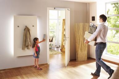 Un hombre cruzando por una puerta automática accionada por una niña