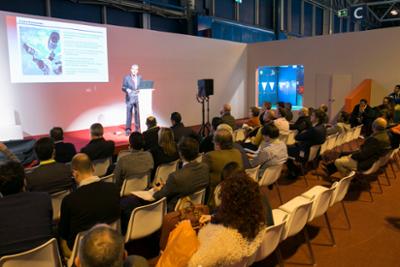 A speaker giving a talk in the auditorium of the SMART DOORS trade fair