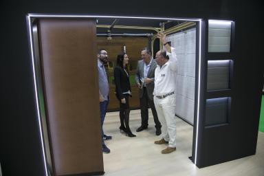 Professionals observing the features of an automatic door at one of the SMART DOORS booths.