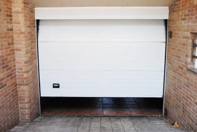 Automatic sectional garage door for a garage of a house