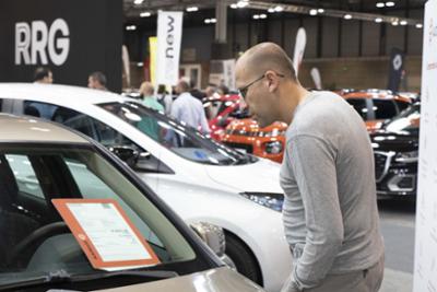 futuro comprador leyendo las características y precio de un vehículo en exposición